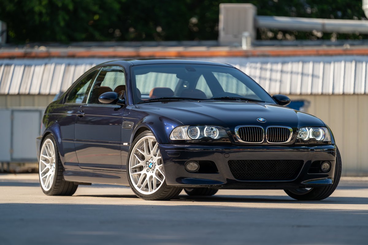 Carbon Black 2002 BMW M3 E46 coupe with silver multi-spoke rims.