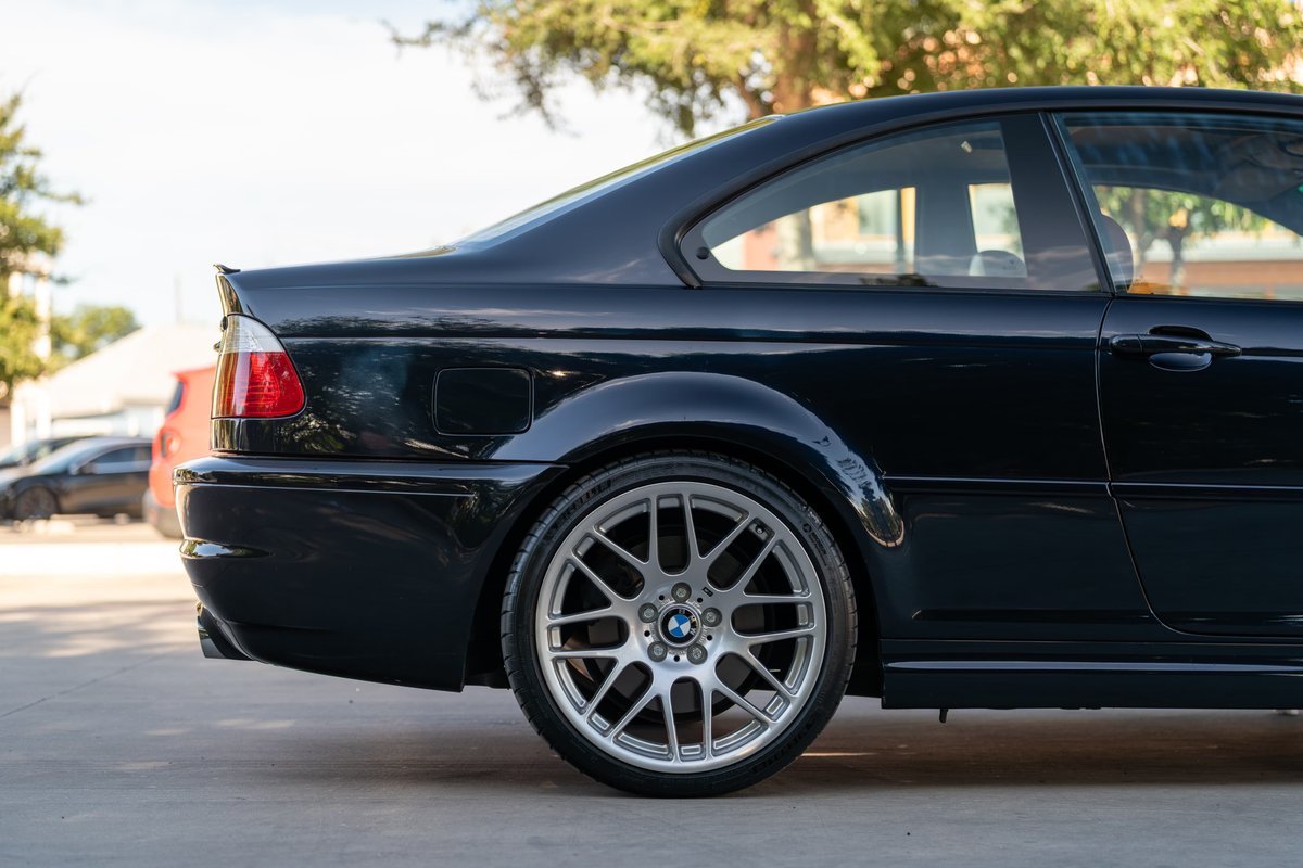 Rear quarter view of a black 2002 BMW M3 coupe, featuring M-Parallel rims.