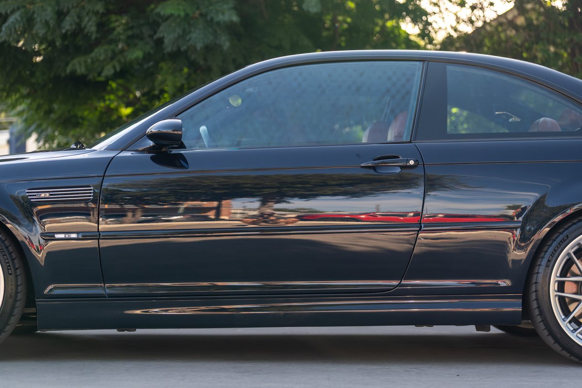 Carbon Black 2002 BMW M3 coupe side profile. Features M3 fender vent, body trim, and alloy rims.