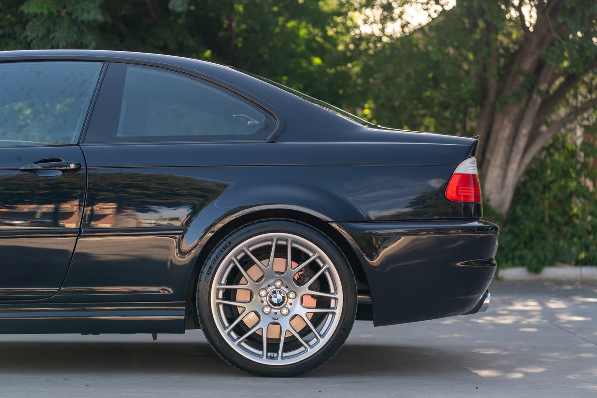 Rear view of a black 2002 BMW M3 coupe featuring its iconic CSL rims and silver brake calipers.