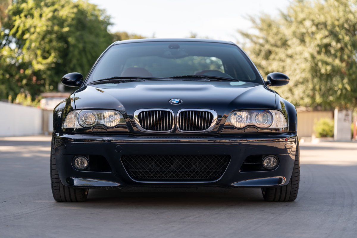 Front view of a black 2002 BMW M3 with chrome kidney grille and round headlights.