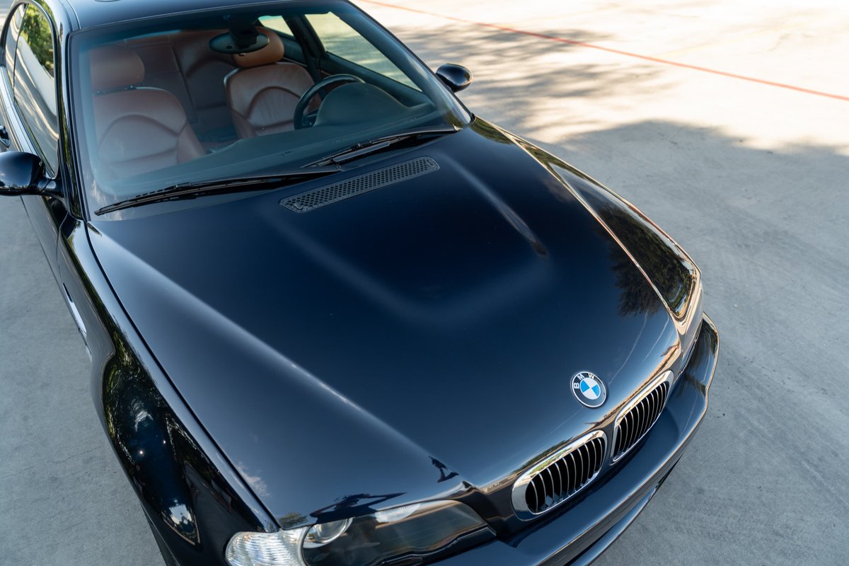 Carbon Black 2002 BMW M3 coupe with tan leather interior, hood scoop, and chrome grille.