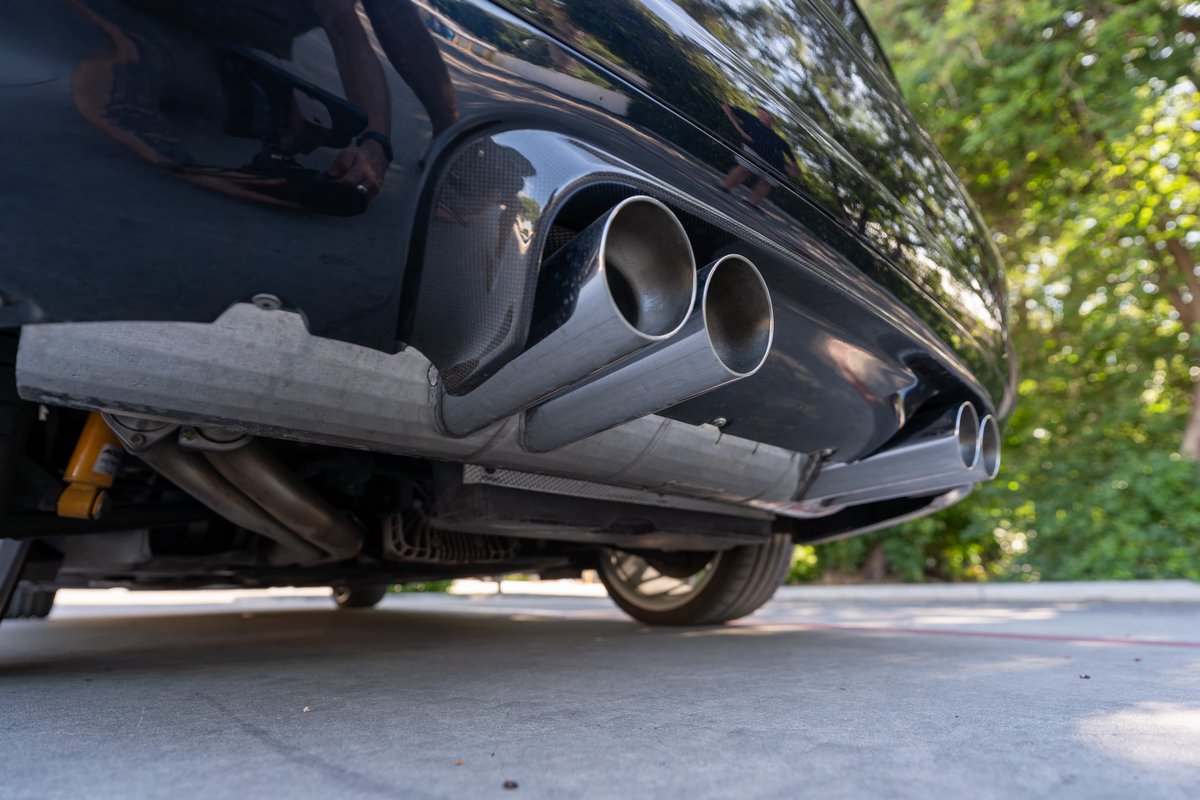 Rear view of a black 2002 BMW M3, showing quad exhaust tips and undercarriage details.