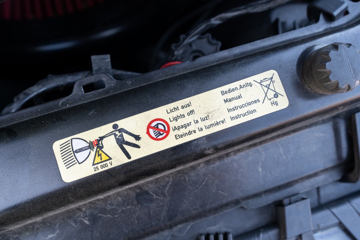 Sticker on a 2002 BMW M3 warns of 25,000 volts and mercury.