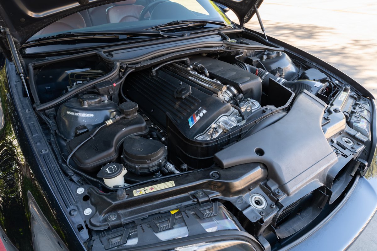 2002 BMW M3 in Carbon Black, showing the engine bay and M-power V8 engine.