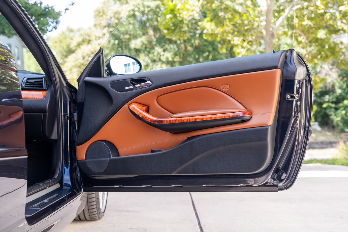 Carbon Black 2002 BMW M3 E46 door panel with tan leather, wood trim, and black carpet.