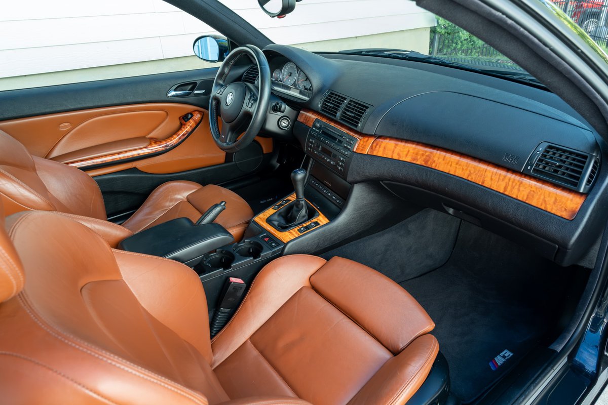 2002 BMW M3 convertible interior with tan leather seats, wood trim, and M3 floor mats.