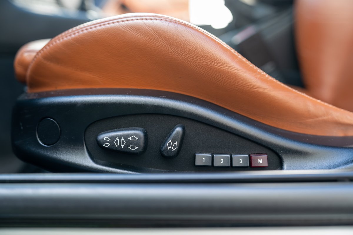 Close-up of brown leather power seat controls and memory buttons (1, 2, 3, M) in a 2002 BMW M3.