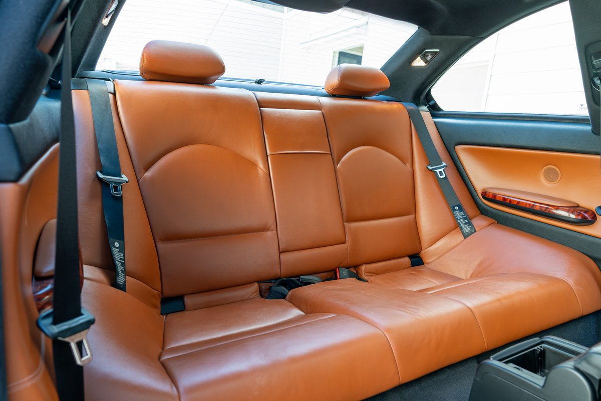 2002 BMW M3 E46 interior with tan leather rear seats and wood trim door panel.