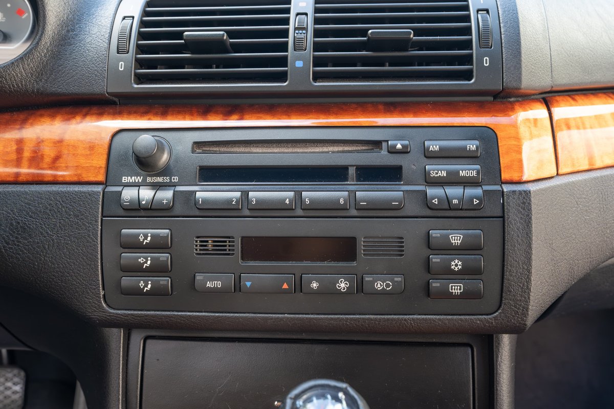 Interior of a 2002 BMW M3 with wood trim and BMW Business CD stereo.