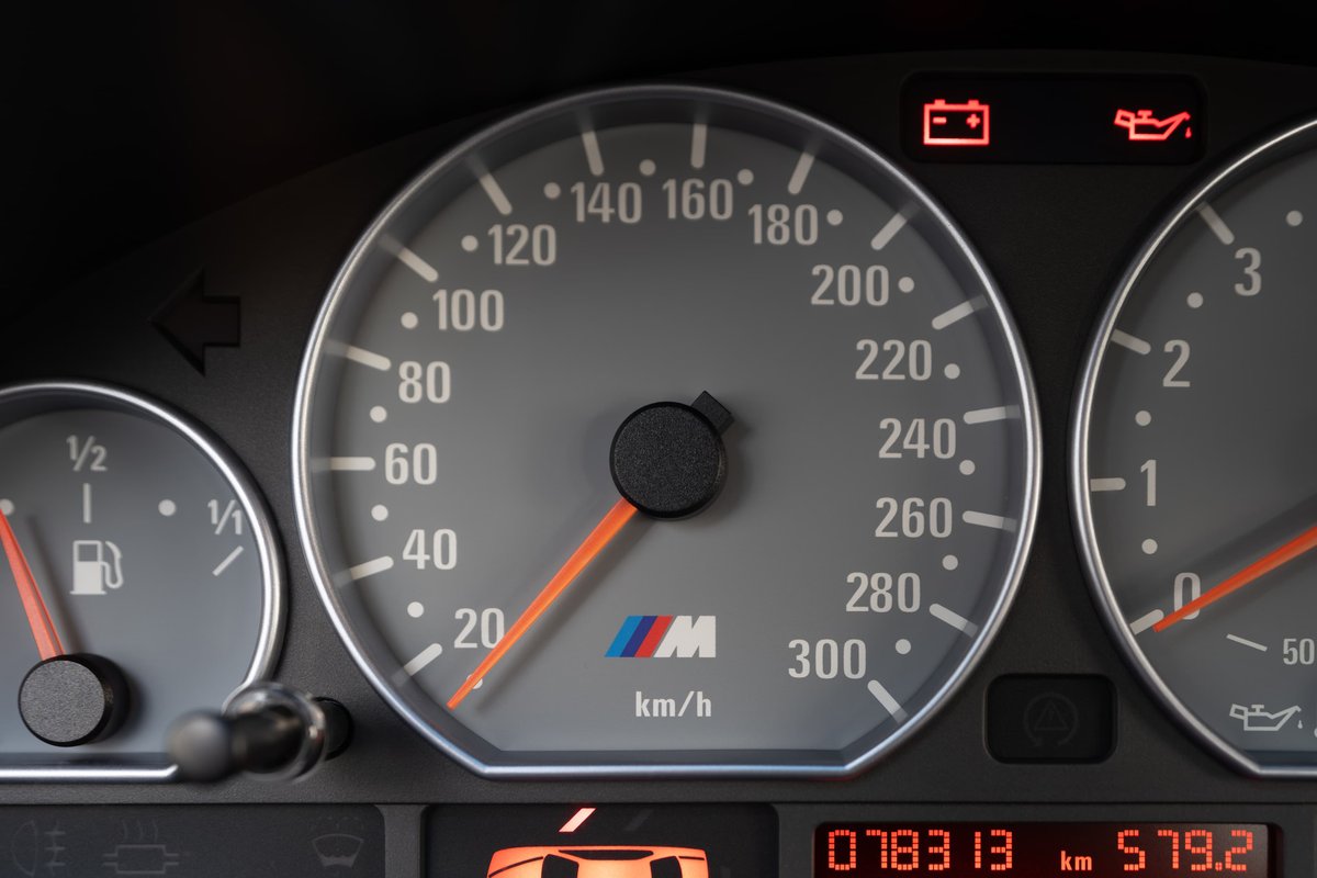 Dashboard of a carbon black 2002 BMW M3. Speedometer shows 20 km/h.