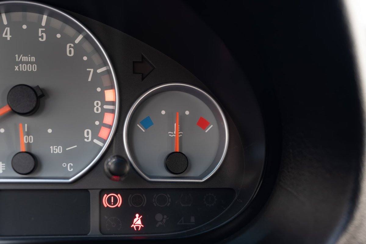 Close-up of 2002 BMW M3 dashboard showing tachometer, coolant temp gauge, and warning lights.