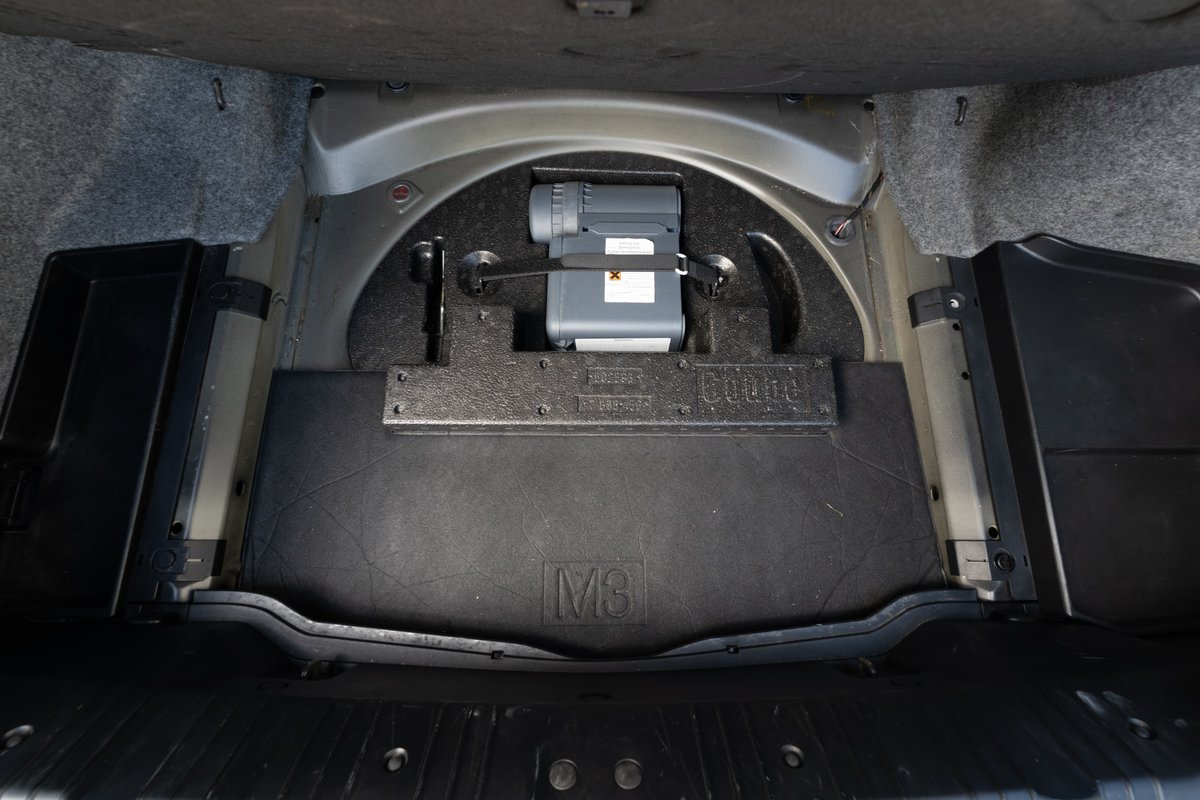 2002 BMW M3 trunk features a compact spare tire kit and M logo trim.
