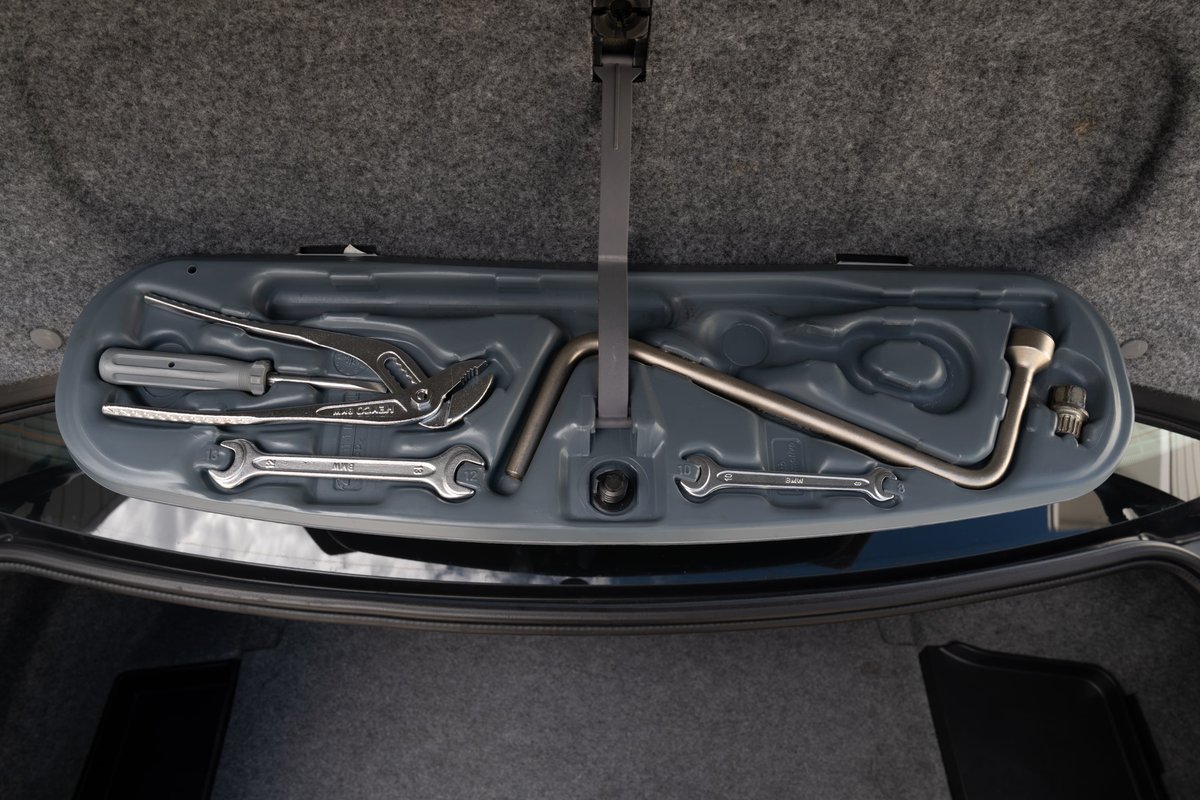 2002 BMW M3 Carbon Black trunk with a tool kit.