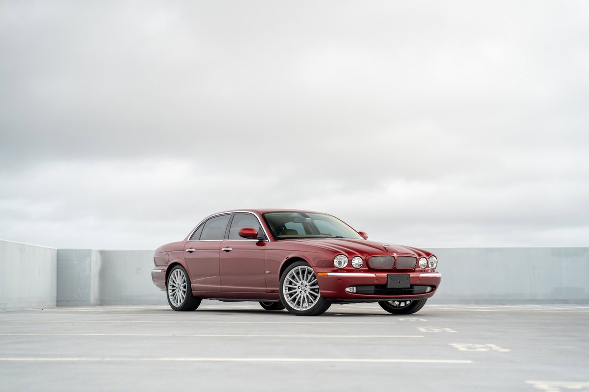 Radiance Red 2006 Jaguar XJR sedan with chrome trim and multi-spoke alloy rims.