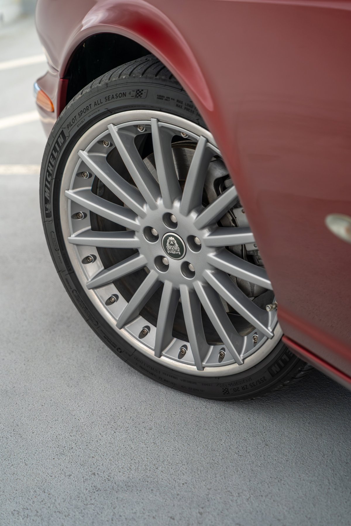 Close up of a 2006 Jaguar XJR's silver multi-spoke alloy rim and Michelin Pilot Sport tire.