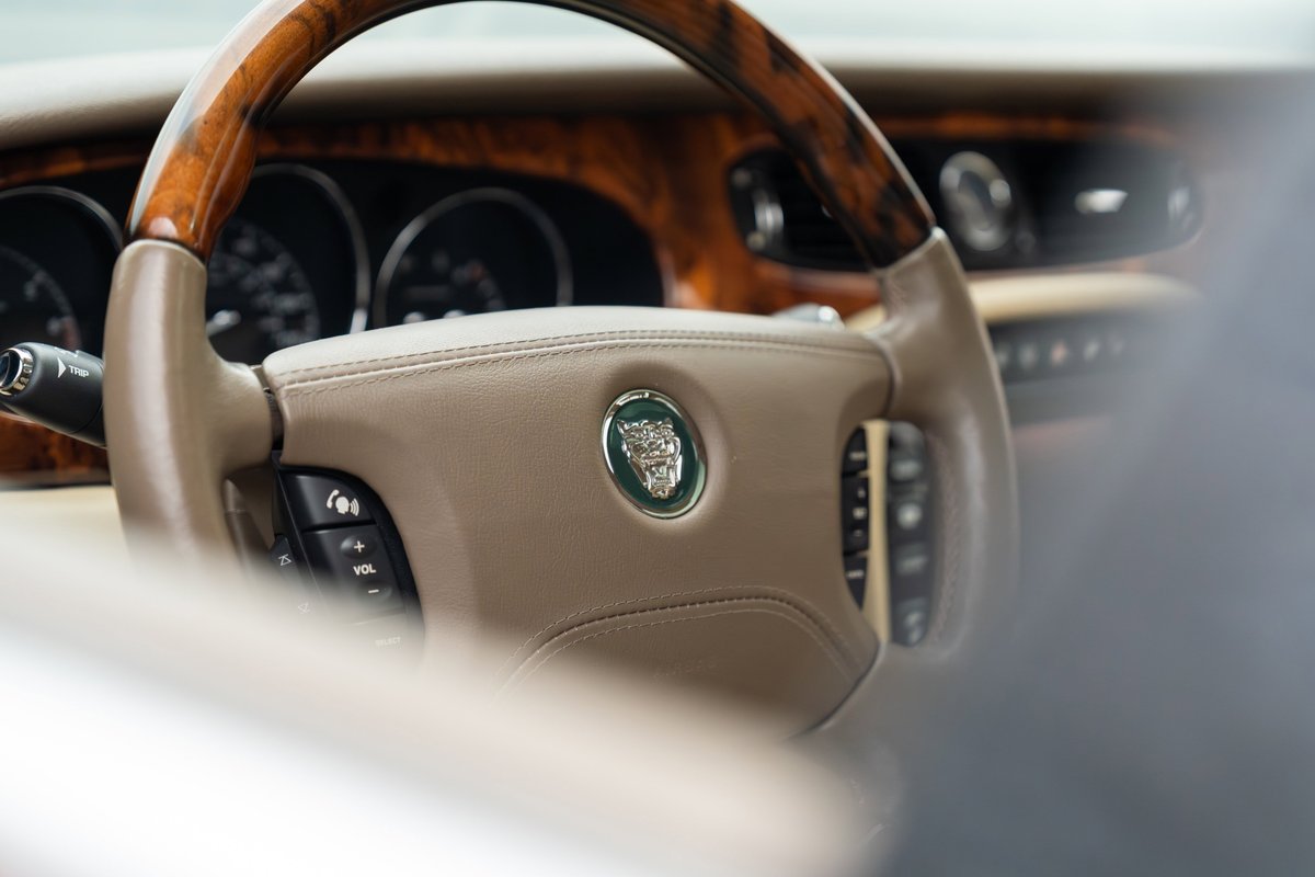 Jaguar XJR steering wheel with wood trim and Jaguar emblem. Radiance Red 2006.