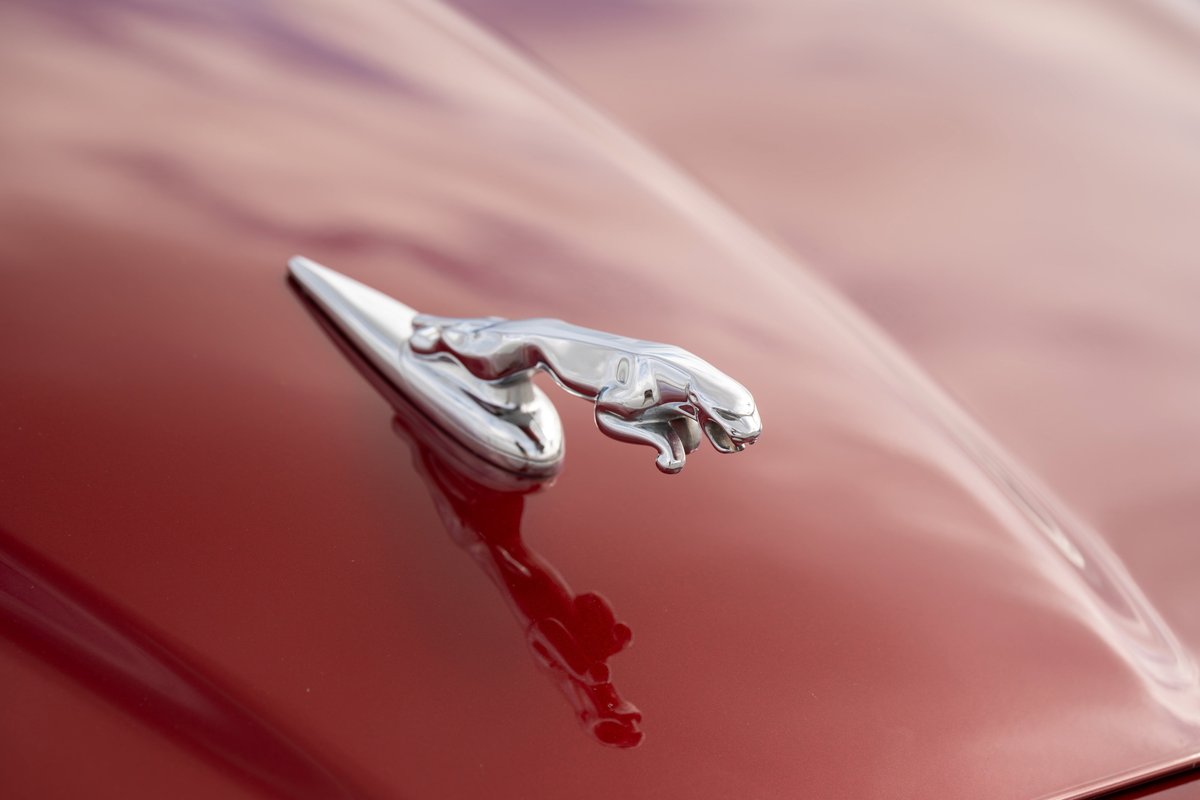 Radiance Red 2006 Jaguar XJR hood ornament with chrome trim.
