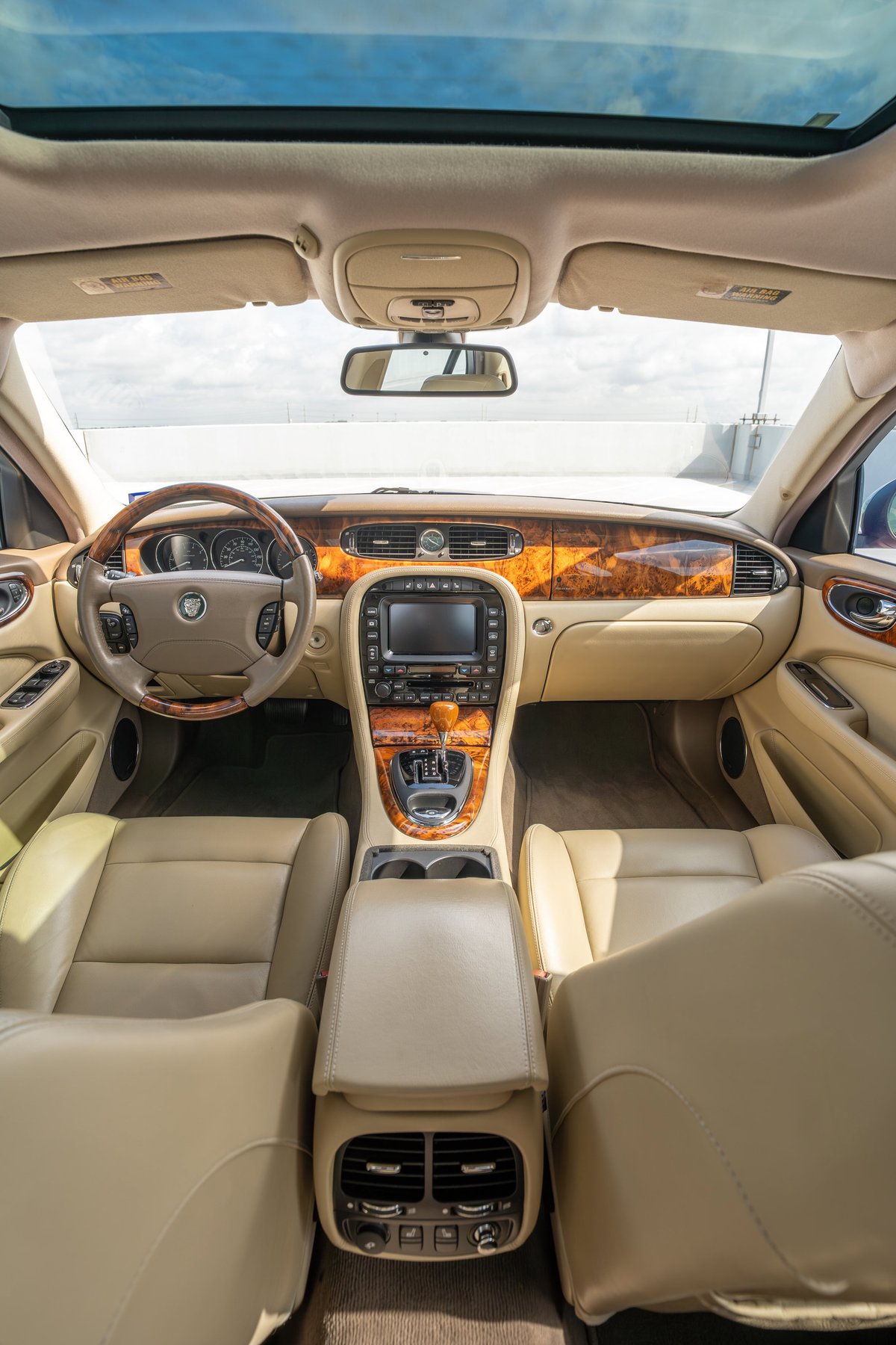 2006 Jaguar XJR interior with wood trim, leather seats, and sunroof.
