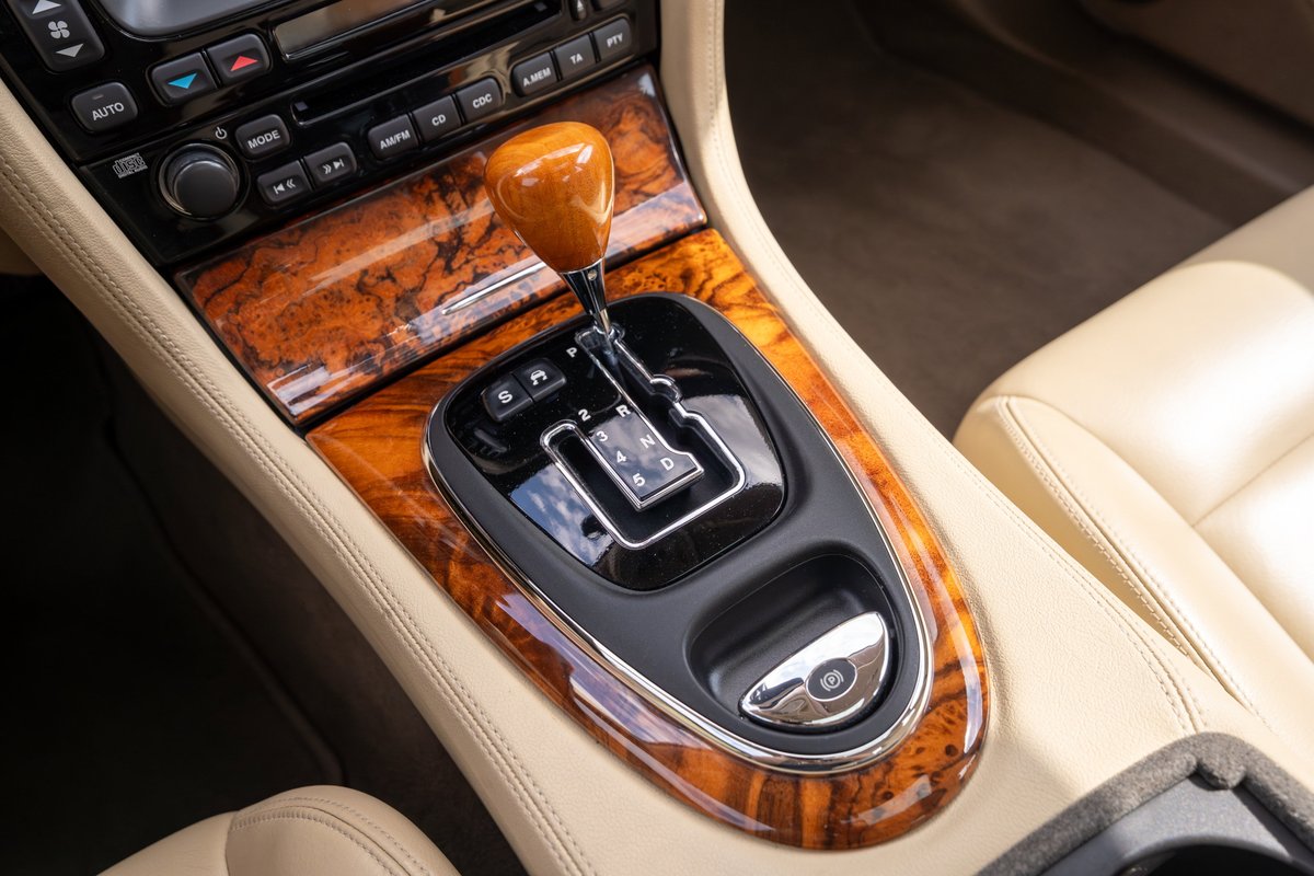2006 Jaguar XJR automatic gear shifter with wood trim and tan leather interior.