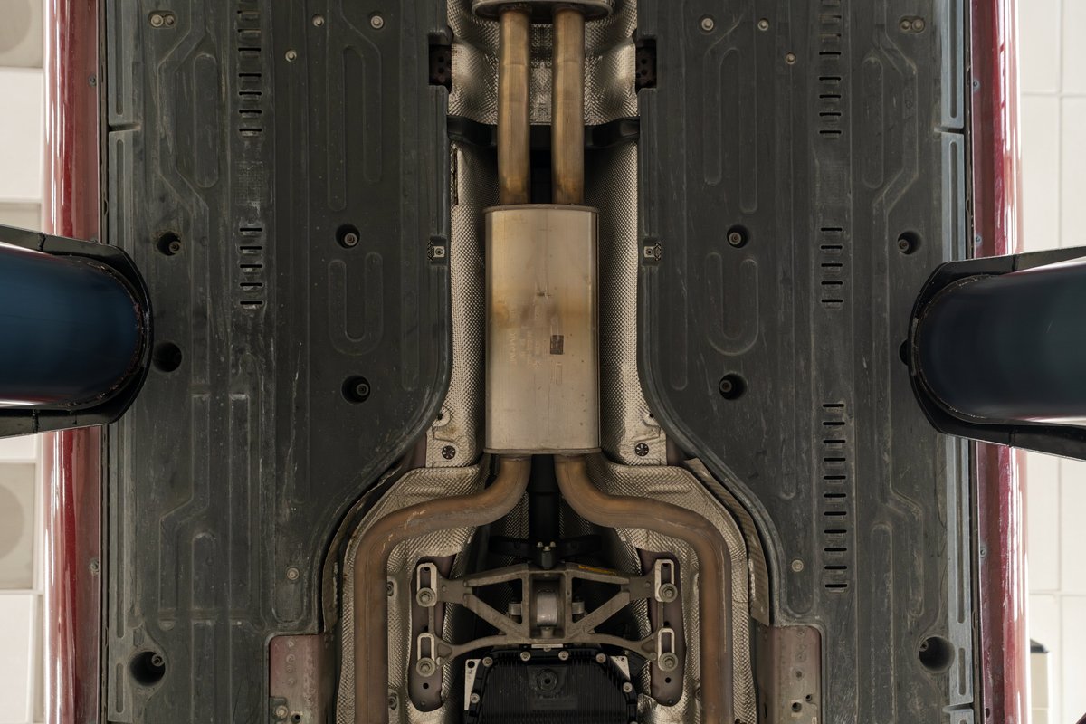 Underside of a 2006 Jaguar XJR in Radiance Red, showing exhaust and underbody trim.