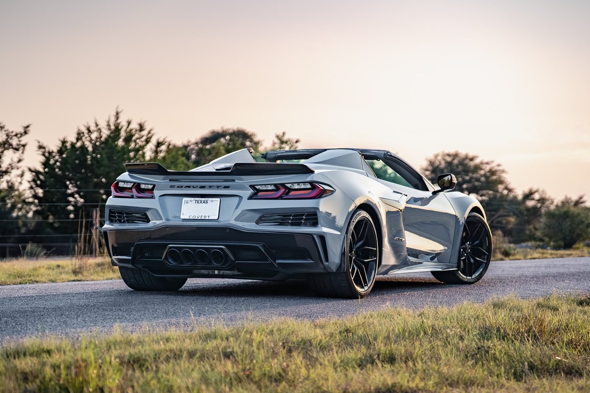 Rear view of a Sea Wolf Gray 2025 Chevrolet Corvette Z06 convertible with black rims and a prominent rear spoiler.