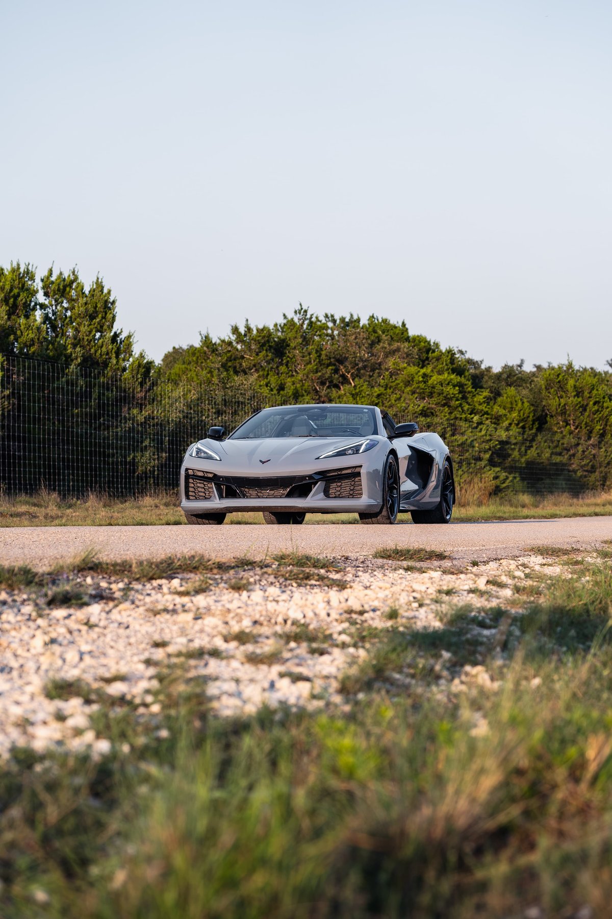 A 2025 Chevrolet Corvette Z06 in Sea Wolf Gray cruises on a gravel road.