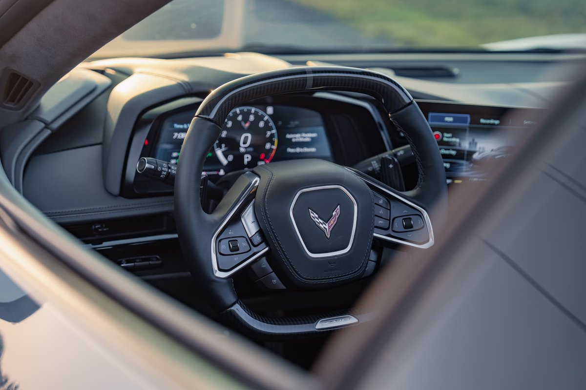 2025 Chevrolet Corvette Z06 interior: digital dash, steering wheel with Z06 logo, carbon fiber trim.