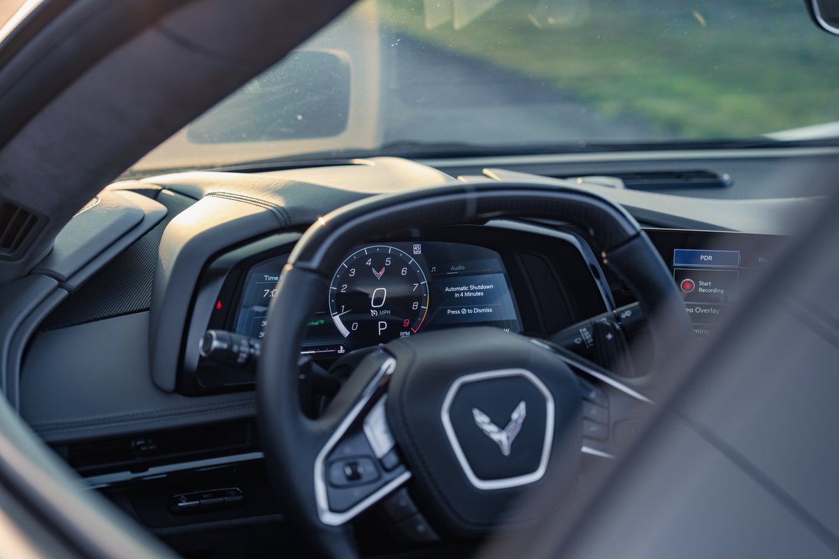 2025 Chevrolet Corvette Z06 interior, gray trim, digital dashboard displays speed and gear.