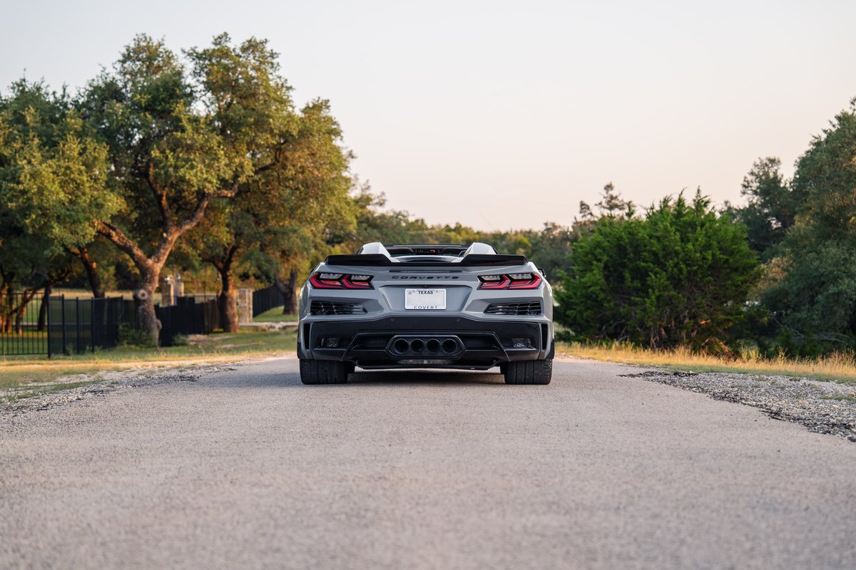 Rear view of a gray 2025 Chevrolet Corvette Z06 convertible with quad exhaust tips.