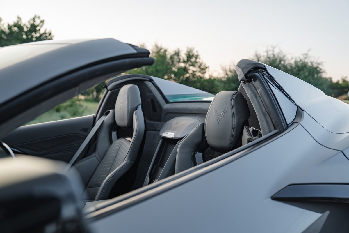Gray 2025 Chevrolet Corvette Z06 convertible interior with embossed seat emblems.