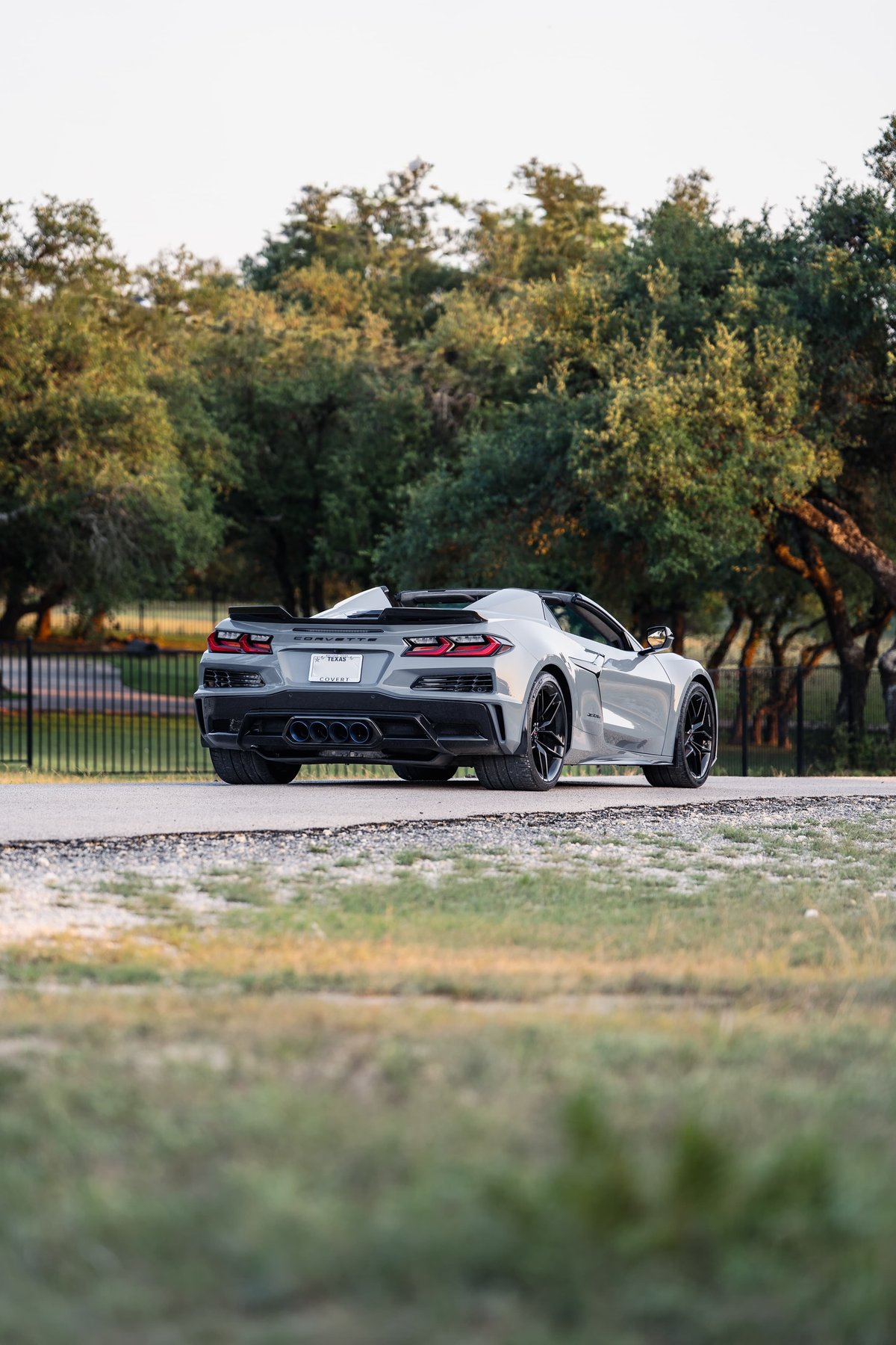 Rear view of a Sea Wolf Gray 2025 Chevrolet Corvette Z06 with black rims and aggressive trim.