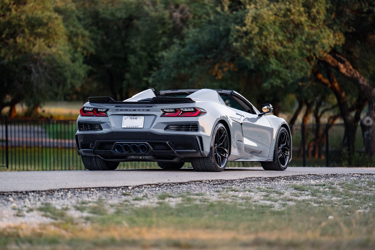 Rear view of a Sea Wolf Gray 2025 Chevrolet Corvette Z06 convertible with black rims and trim.