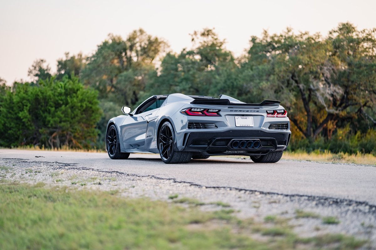 Rear view of a Sea Wolf Gray 2025 Chevrolet Corvette Z06 with black rims and a performance spoiler.