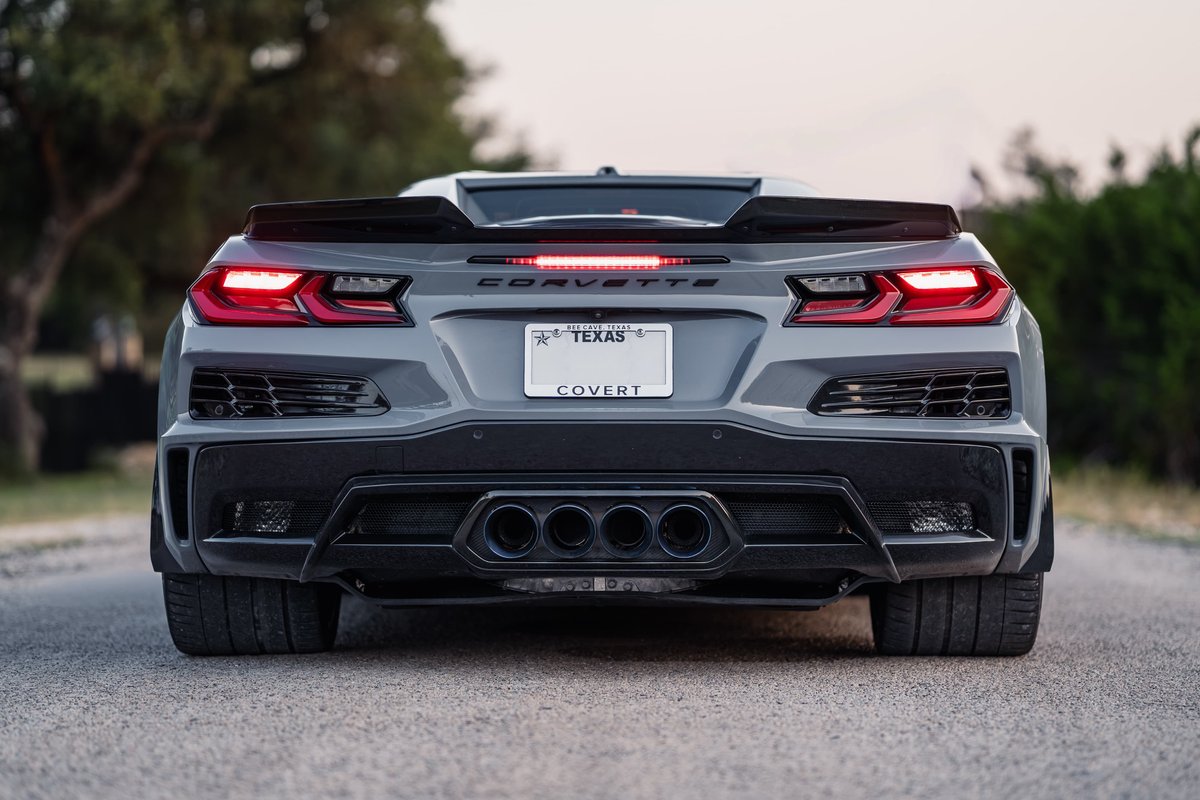 Rear view of a gray 2025 Chevrolet Corvette Z06 with quad exhaust tips and a rear spoiler.