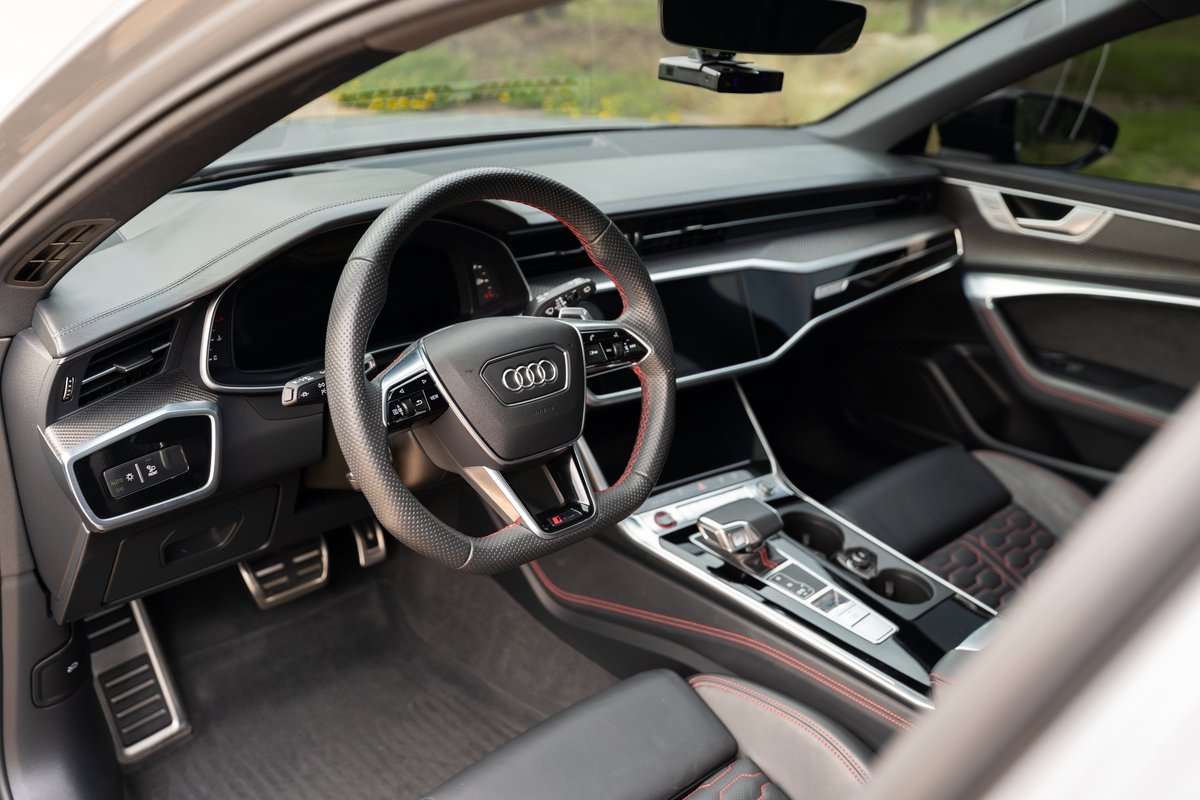 Interior of a Nardo Grey 2022 Audi RS6 with red trim stitching and a sporty steering wheel.