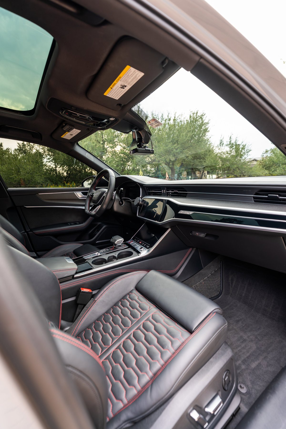 2022 Audi RS6 interior: Nardo Grey paint, panoramic sunroof, honeycomb stitched leather seats with red accents.