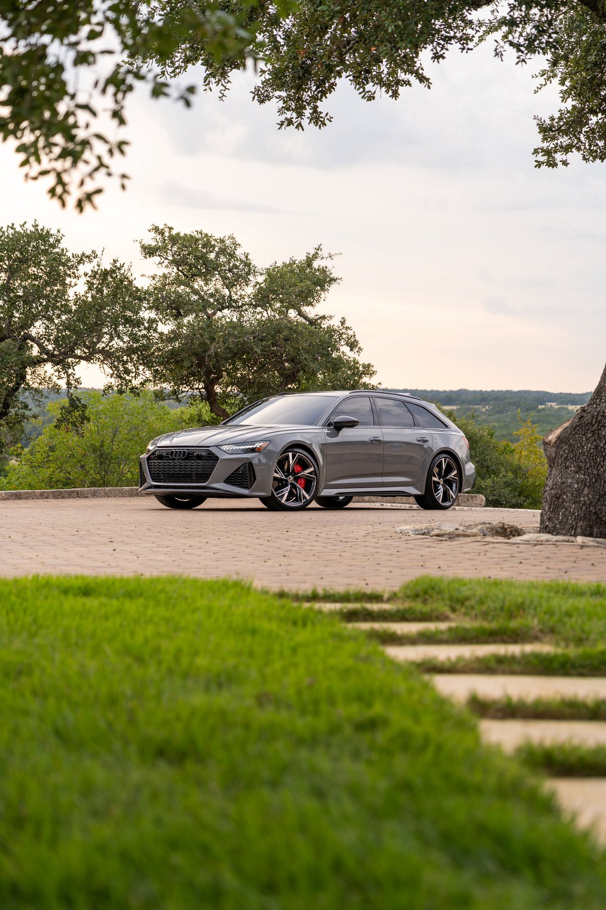 2022 Audi RS6 in Nardo Grey, featuring black trim and red brake calipers on its alloy rims.