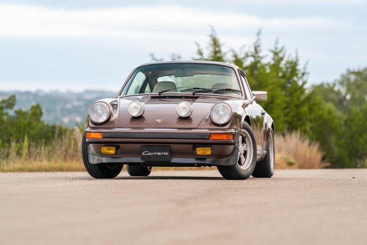Brown 1975 Porsche 911 Carrera with chrome Fuchs wheels and factory fog lights.
