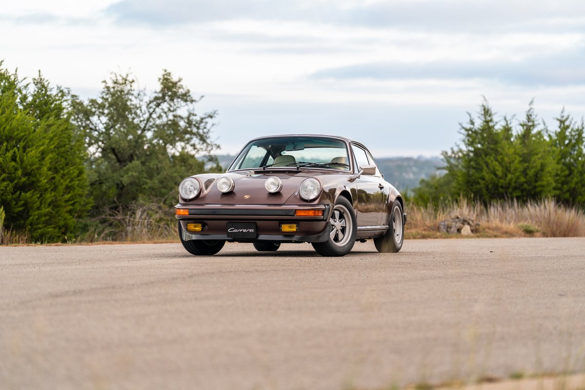 Brown metallic 1975 Porsche 911 Carrera coupe with fog lights and Fuchs rims.