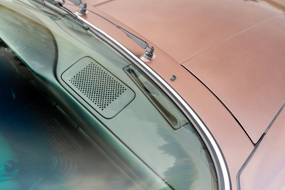 1975 Porsche 911 Carrera hood detail in copper brown metallic paint with chrome trim.