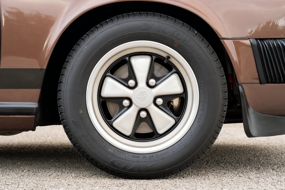 Close-up of a copper brown 1975 Porsche 911 Carrera with Fuchs wheels.