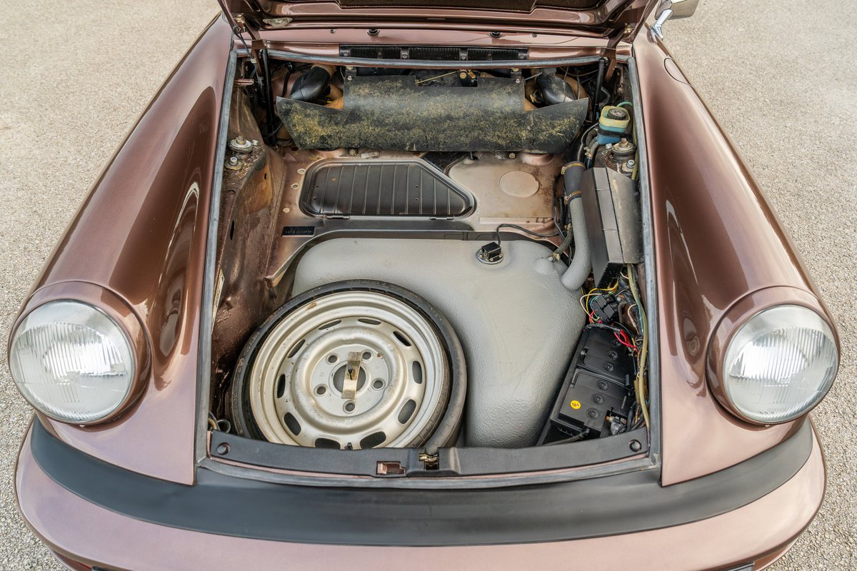 Copper brown metallic 1975 Porsche 911 Carrera's front trunk with spare wheel.