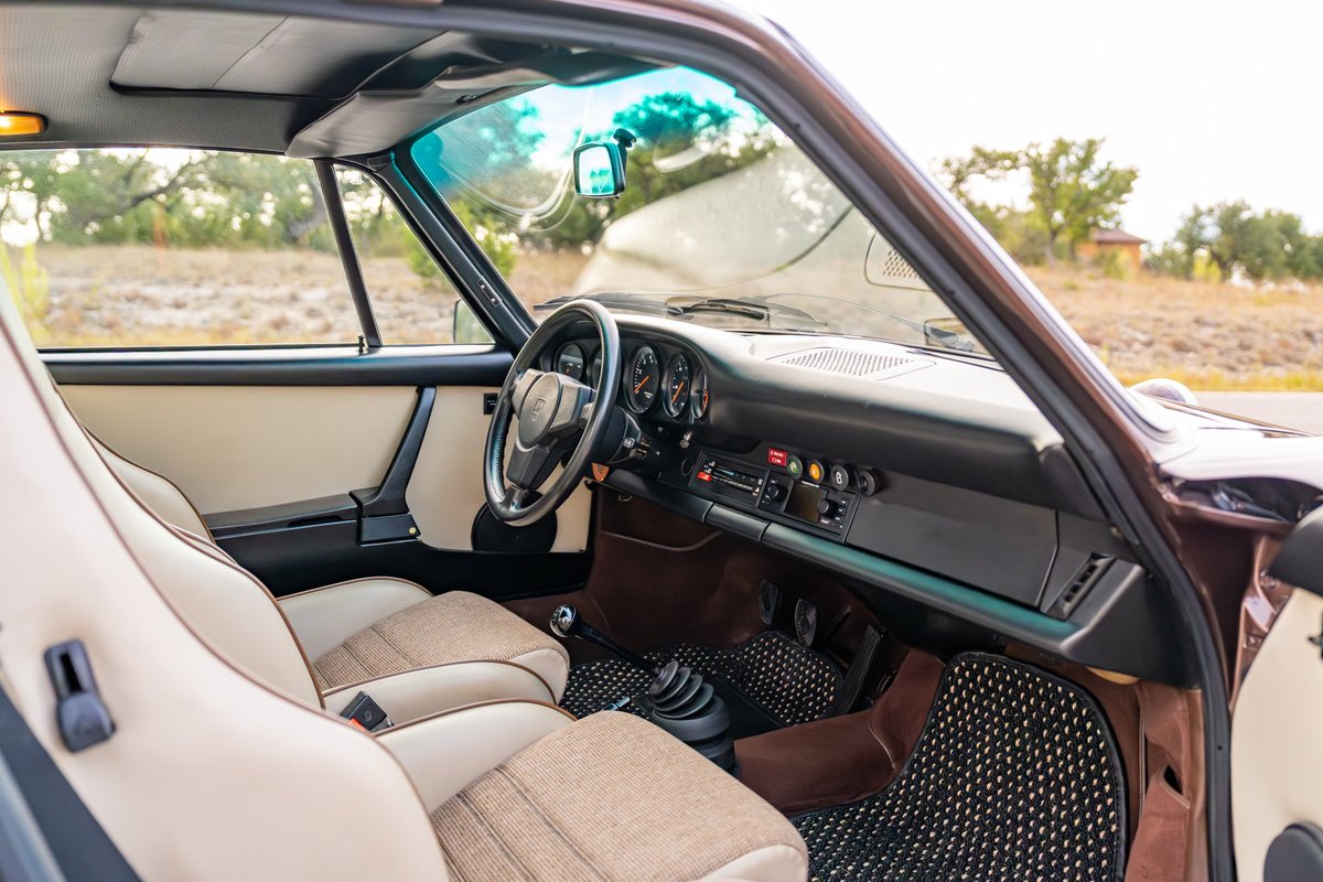 Copper Brown Metallic 1975 Porsche 911 Carrera interior with tan seats, wood trim, and factory radio.