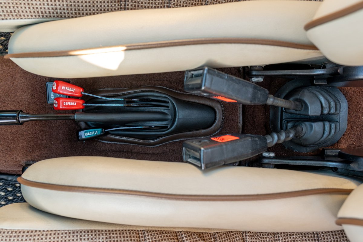1975 Porsche 911 Carrera interior with beige leather trim, brown carpet, and manual transmission shifter.
