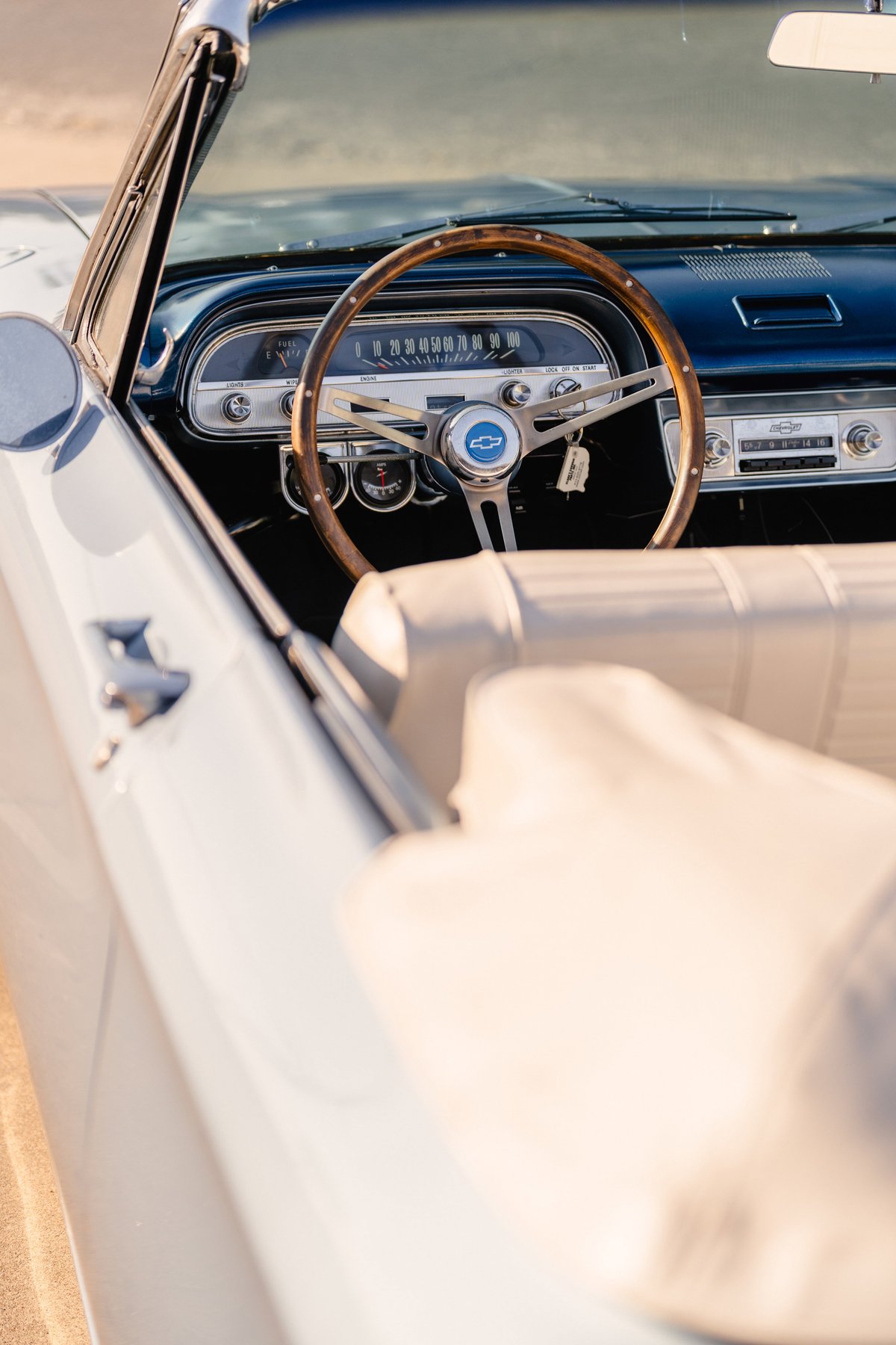 1966 Chevrolet Corvair convertible interior with wood-rimmed steering wheel and blue metallic dash trim.