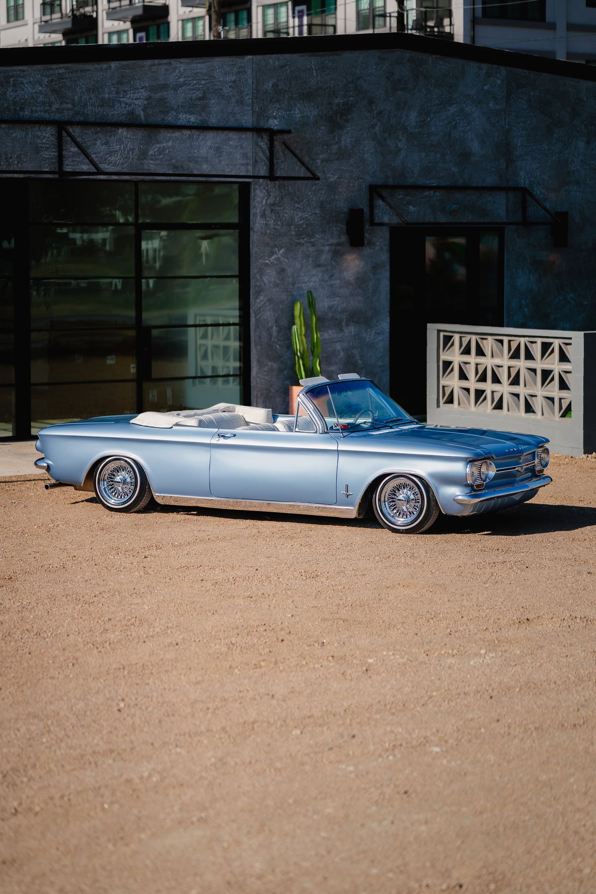 Light blue metallic 1966 Chevrolet Corvair convertible with chrome rims and trim.