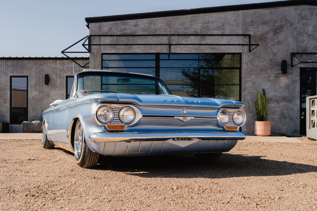 Light blue 1966 Chevrolet Corvair convertible with chrome rims and trim.