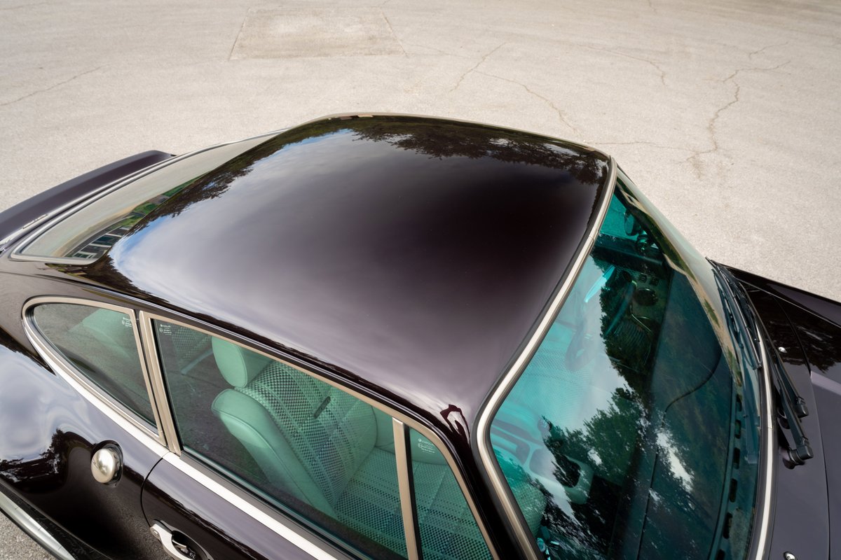Top view of a black 1990 Singer Porsche 911 showing glossy roof and turquoise tinted glass.