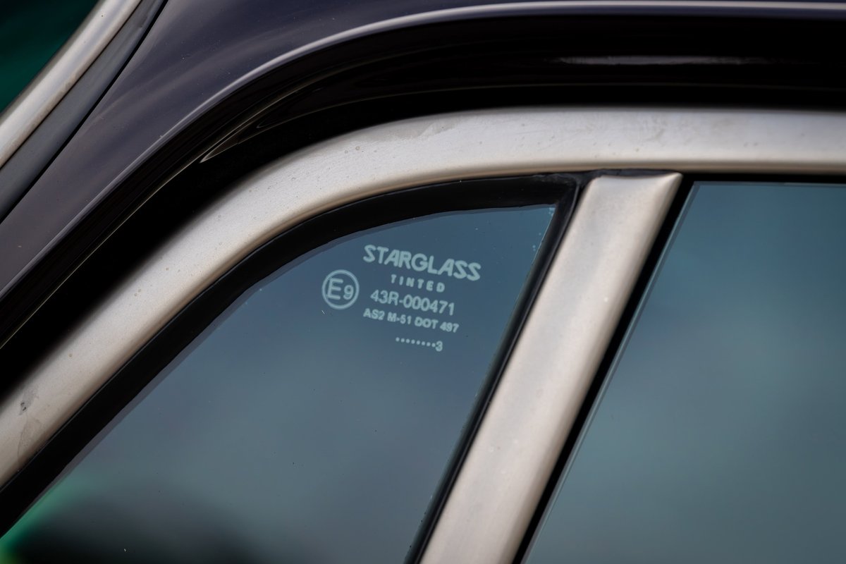 Close-up of a 1990 Porsche 911's tinted Starglass window, showing the A-pillar trim.
